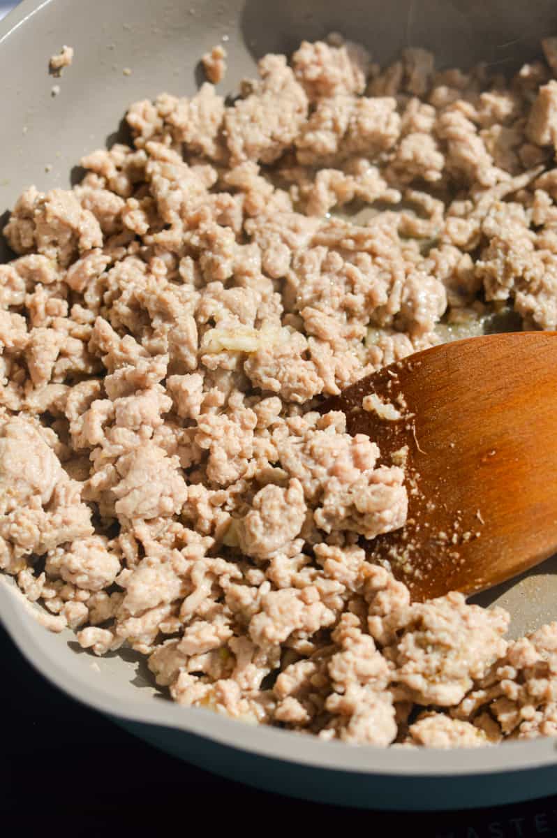Cooking ground chicken in a pan.