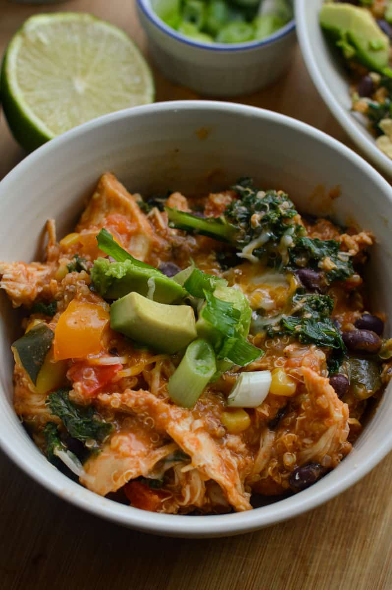 Slow cooker southwest chicken bowls topped with avocado, lime juice and green onions.