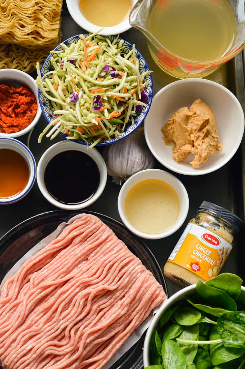 Ingredients including ground chicken, coleslaw mix, veggies, peanut butter, red curry paste, ginger, garlic, oil and spinach.
