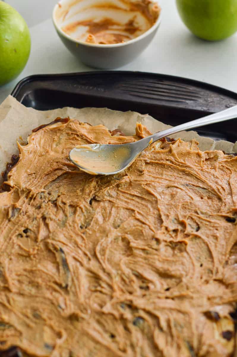Spreading a layer of peanut butter on top of dates.