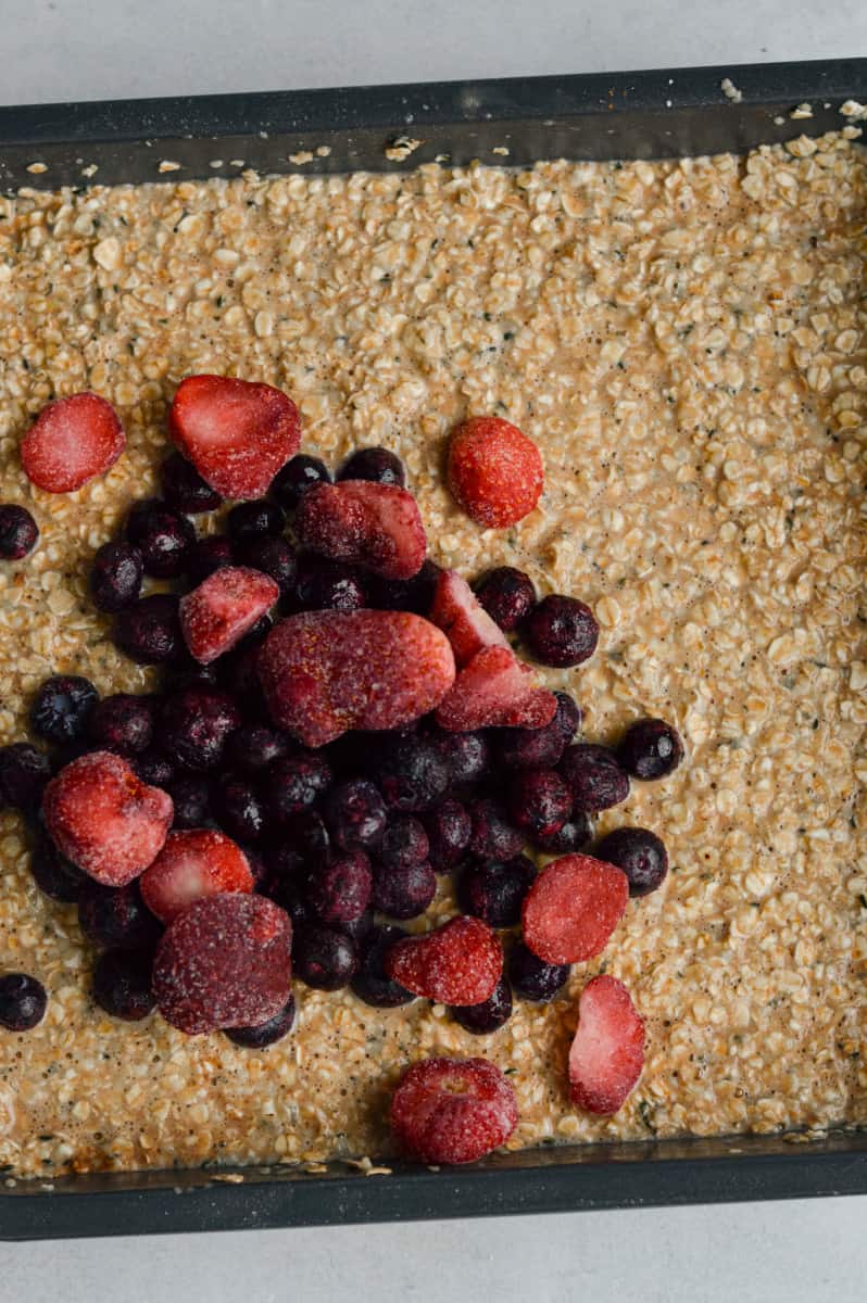 Adding berries into the baked oat mixture.
