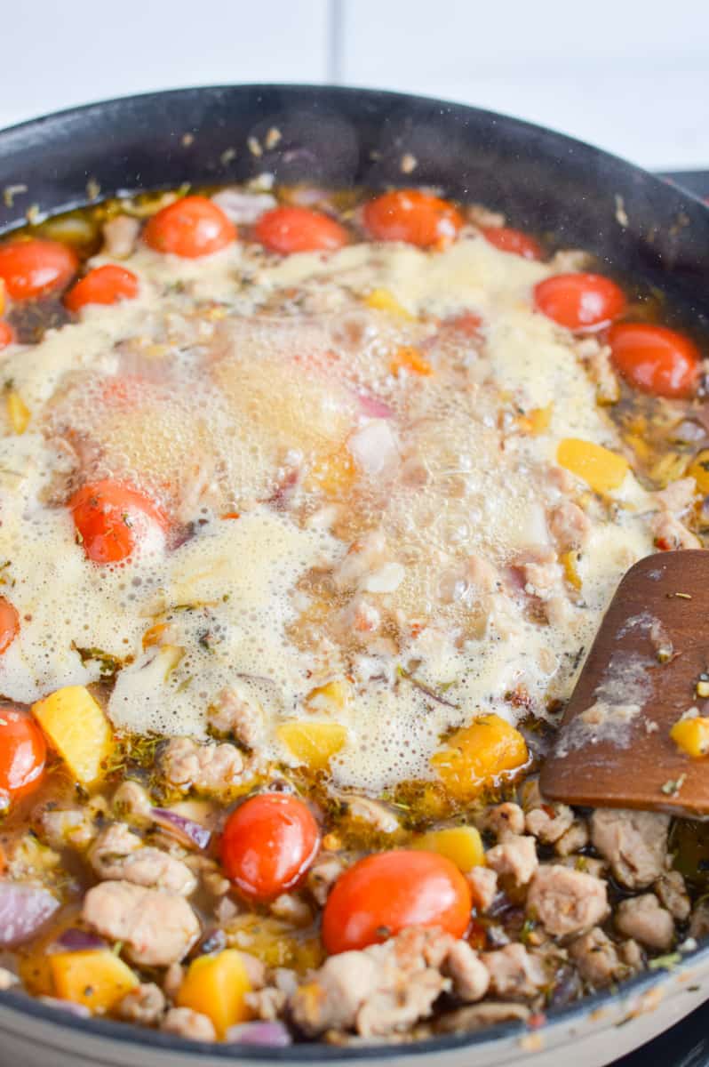 Adding chicken broth to the pan.