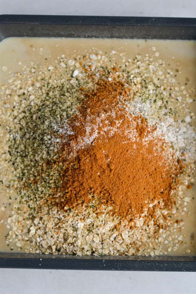Adding oats, hemp seeds, baking powder and cinnamon into the wet ingredients.