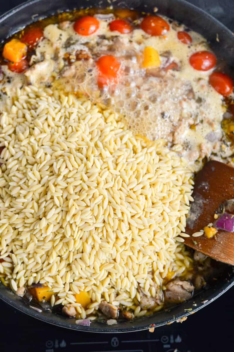 Adding dry orzo to the pan.