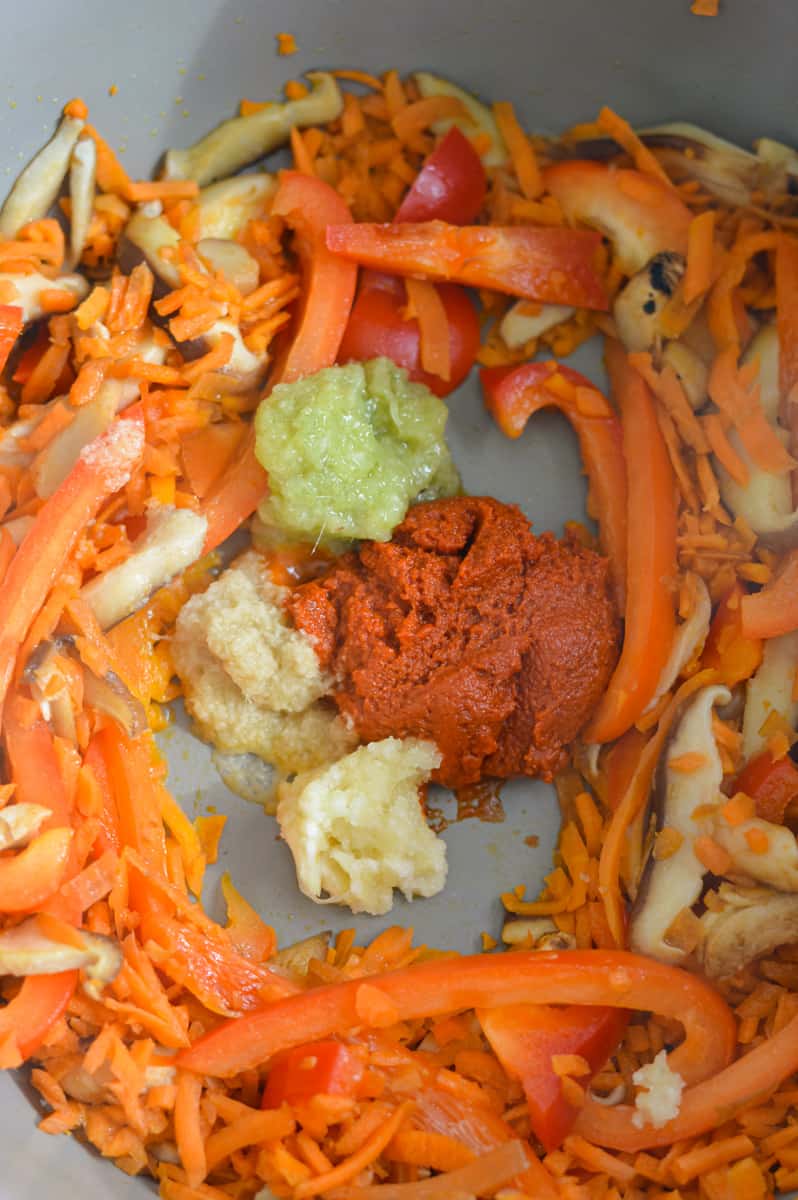 Adding garlic, ginger, curry paste and lemongrass to the pan.