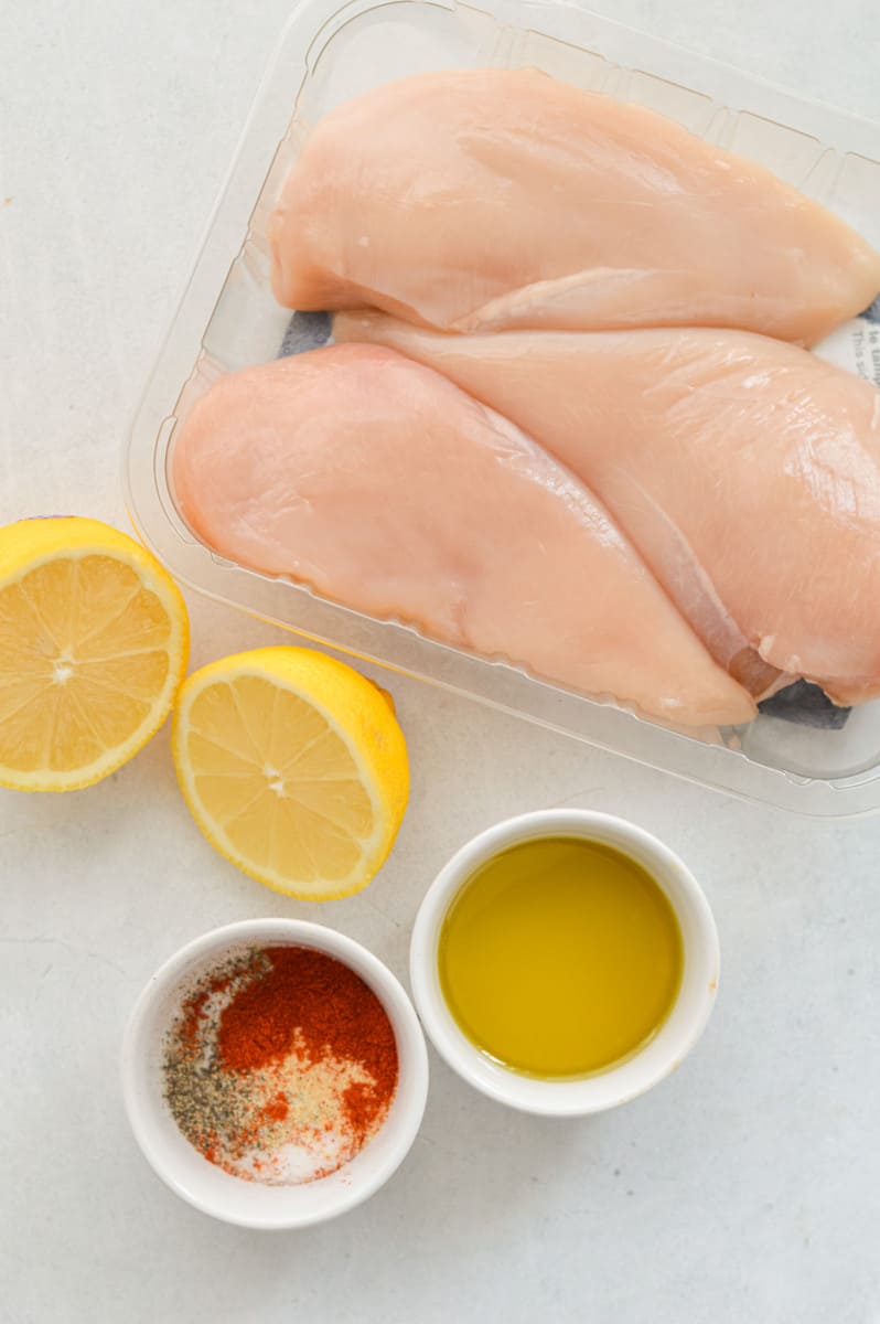Ingredients including chicken breast, lemons, olive oil and spices.