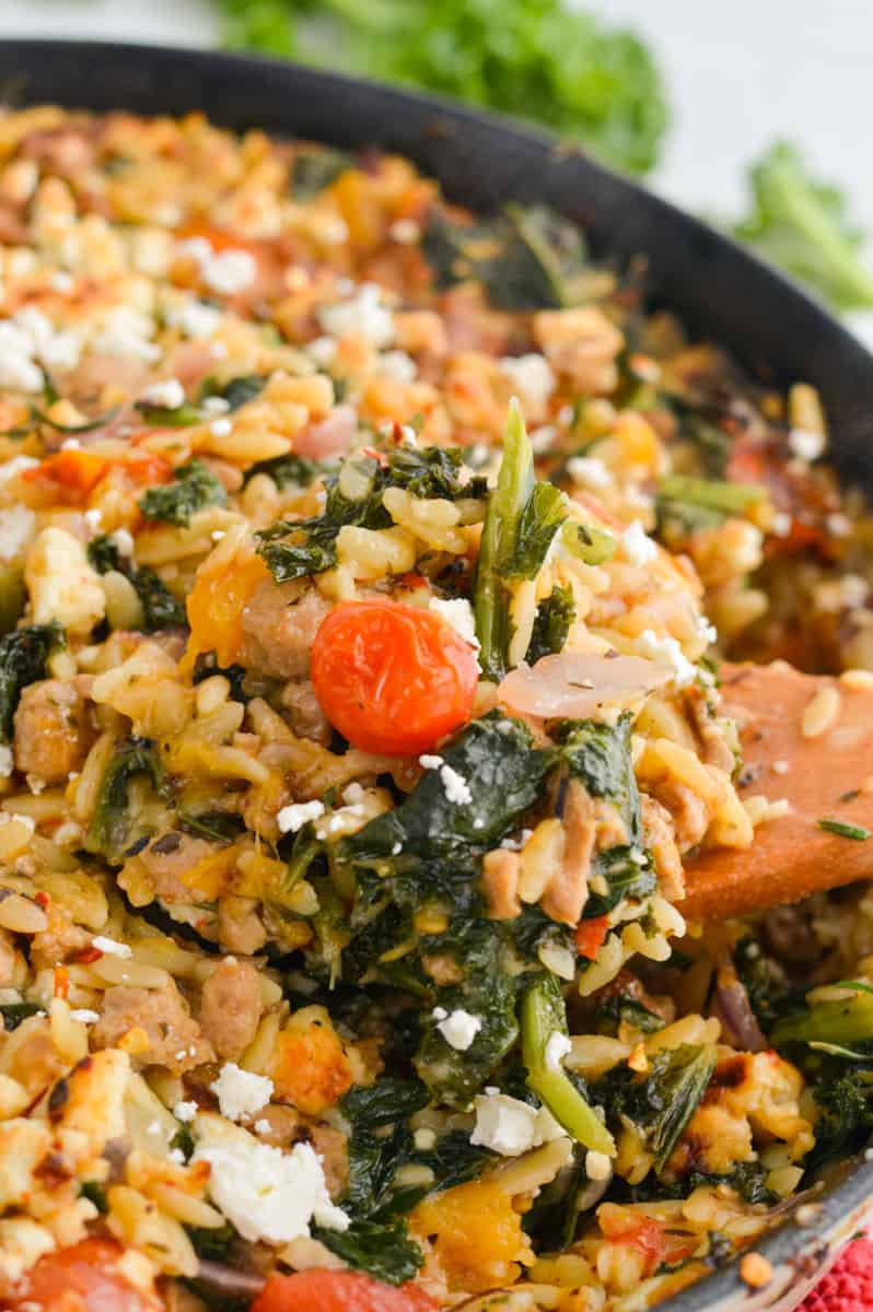 Topping the butternut squash orzo with feta cheese.