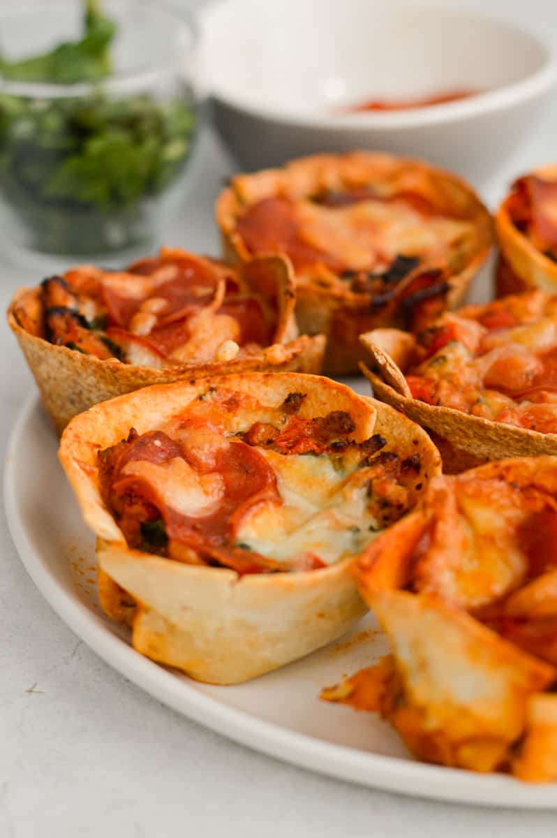 Close up of cheesy pizza cups on a plate.