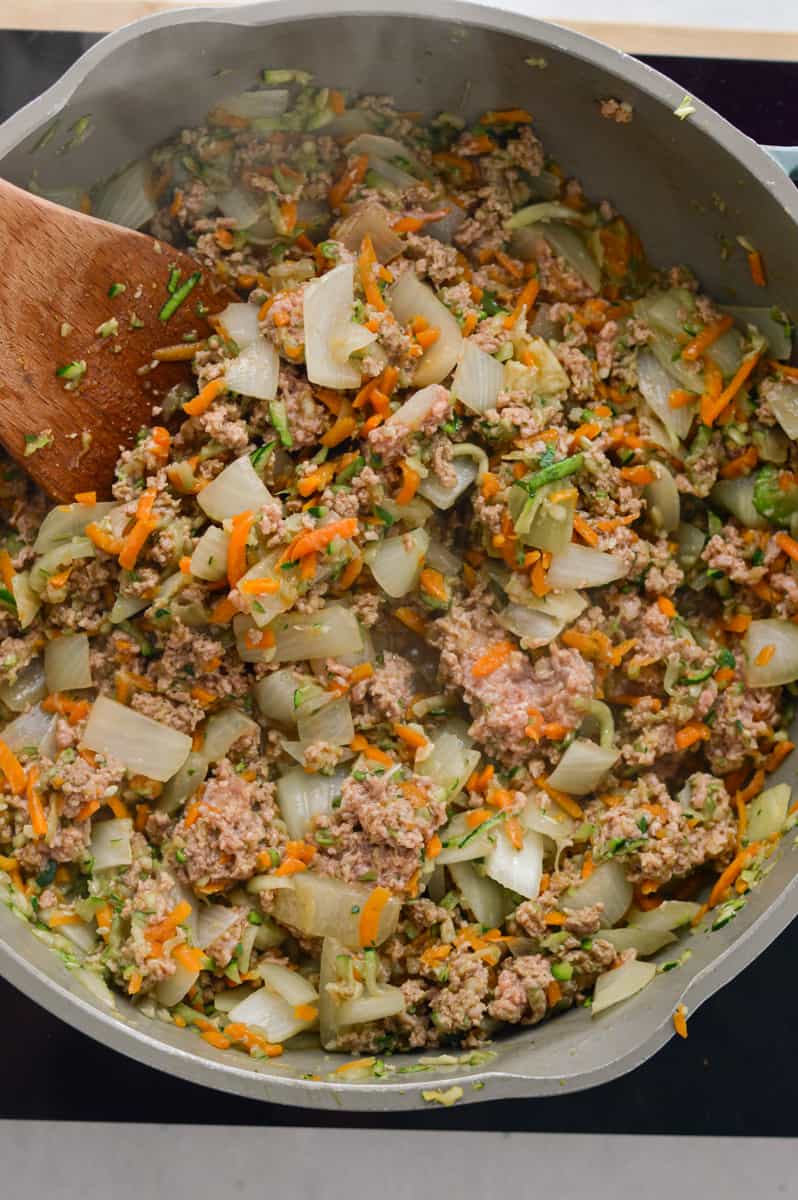 Cooking ground beef with veggies in a pan.
