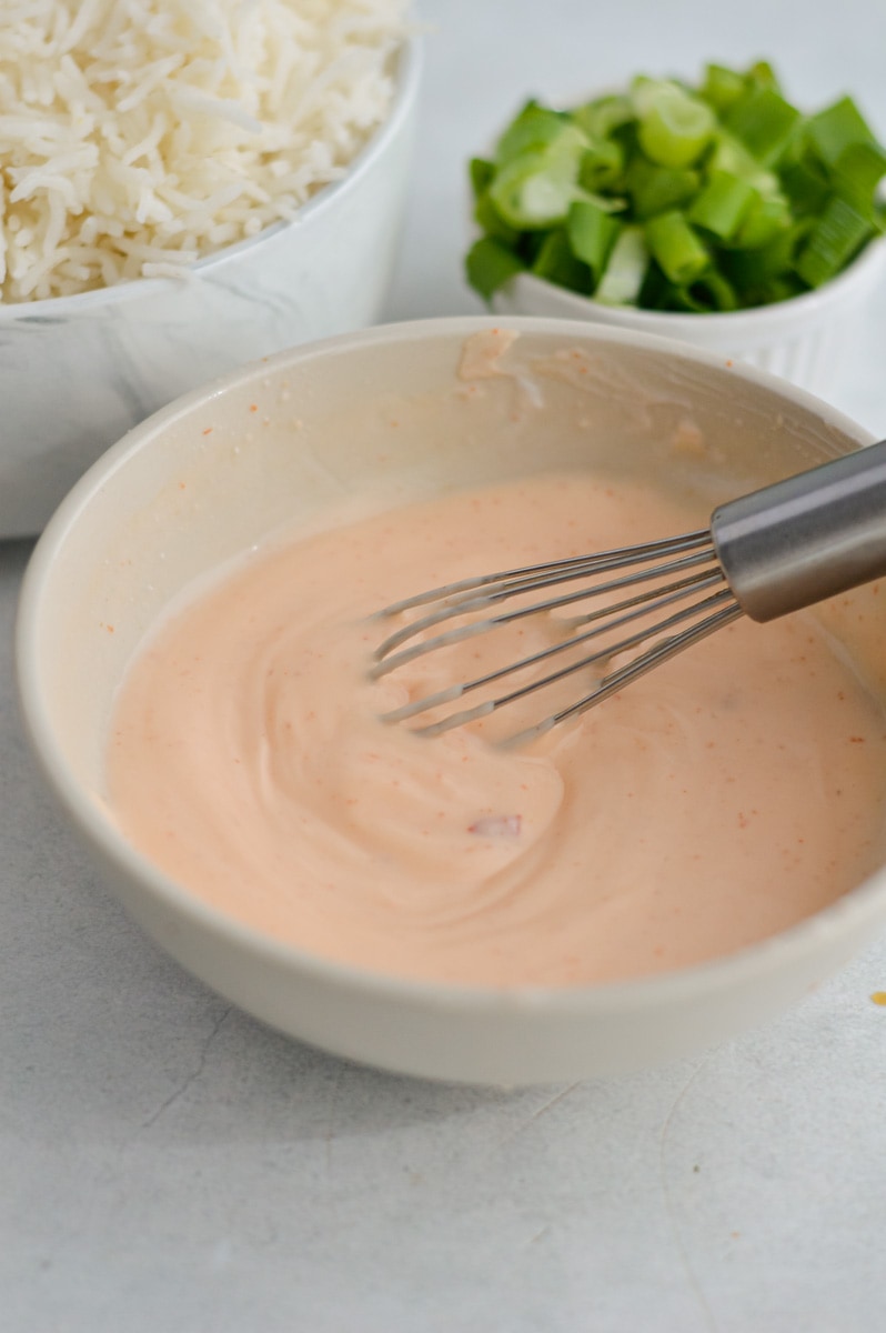 Whisking together sriracha mayo.