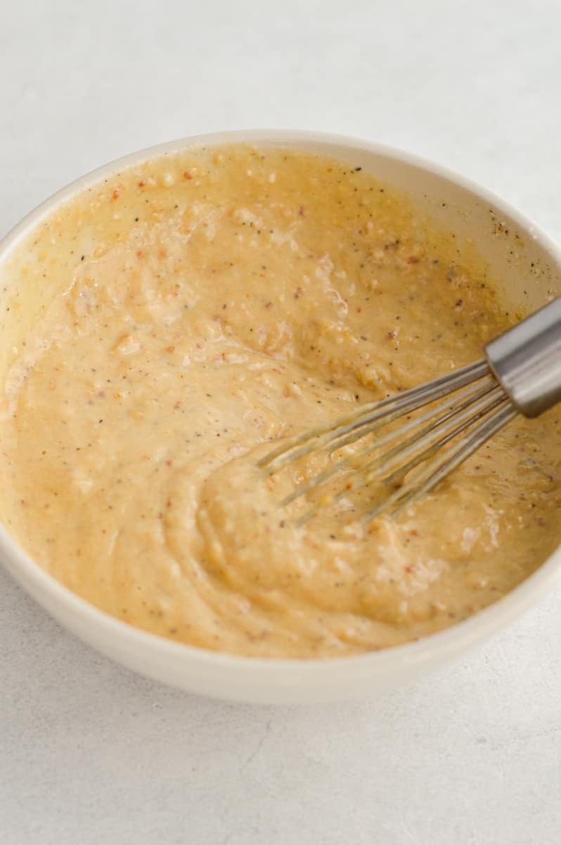 Whisking together parmesan tahini sauce.