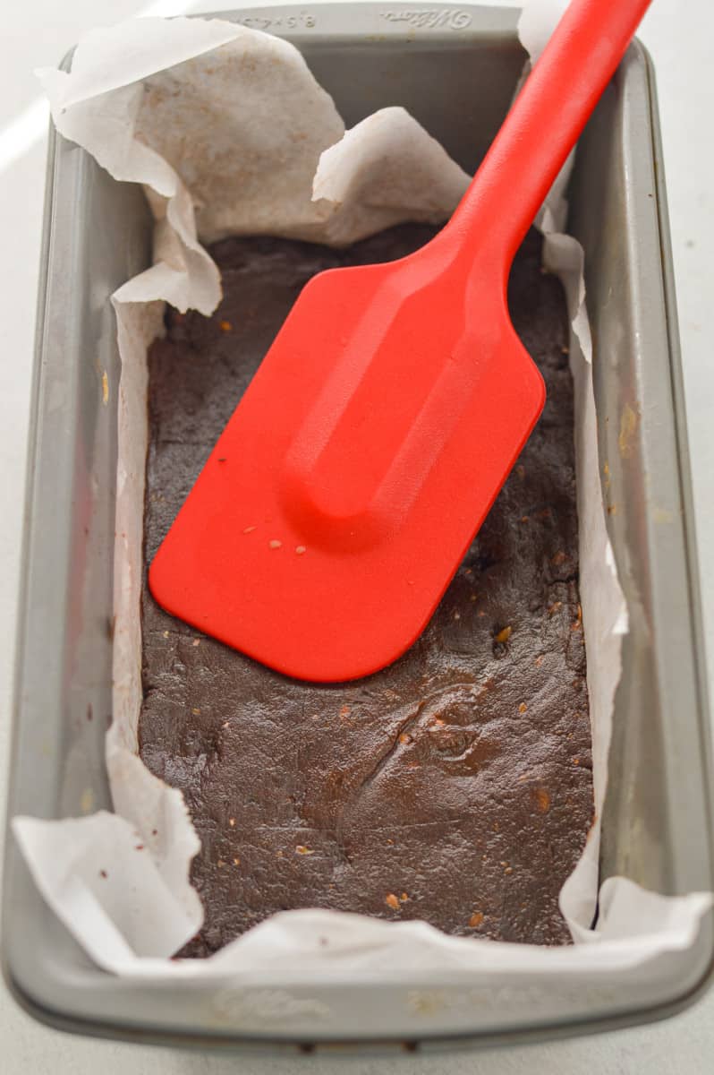 Pressing protein bar mixture into a loaf pan.