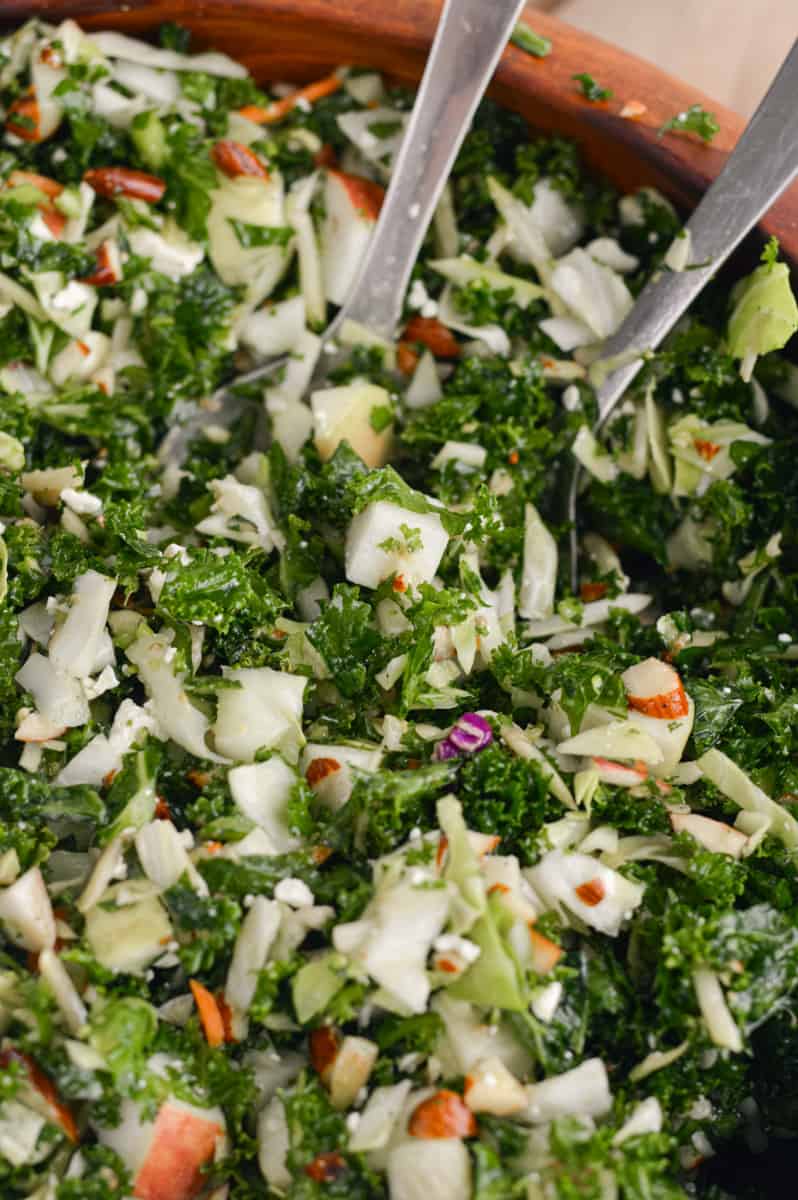 Tossing kale crunch salad with two forks.