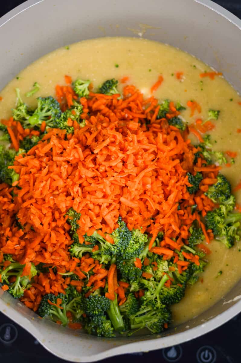 Adding shredded carrot and broccoli into broccoli cheddar soup.