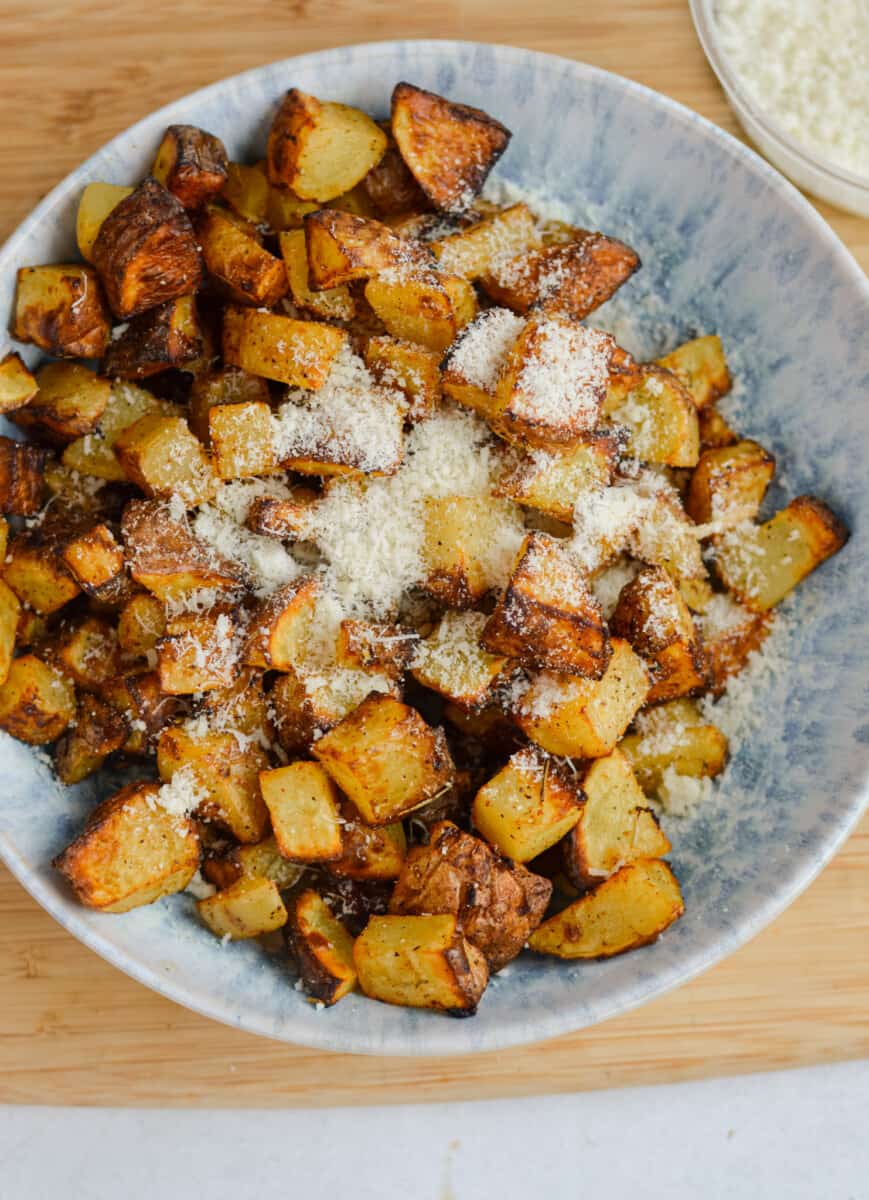 Bowl of crispy air fryer diced potatoes with parmesan.