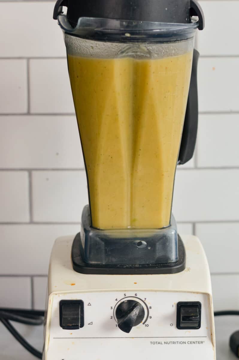 Blending broccoli cheddar soup until smooth.