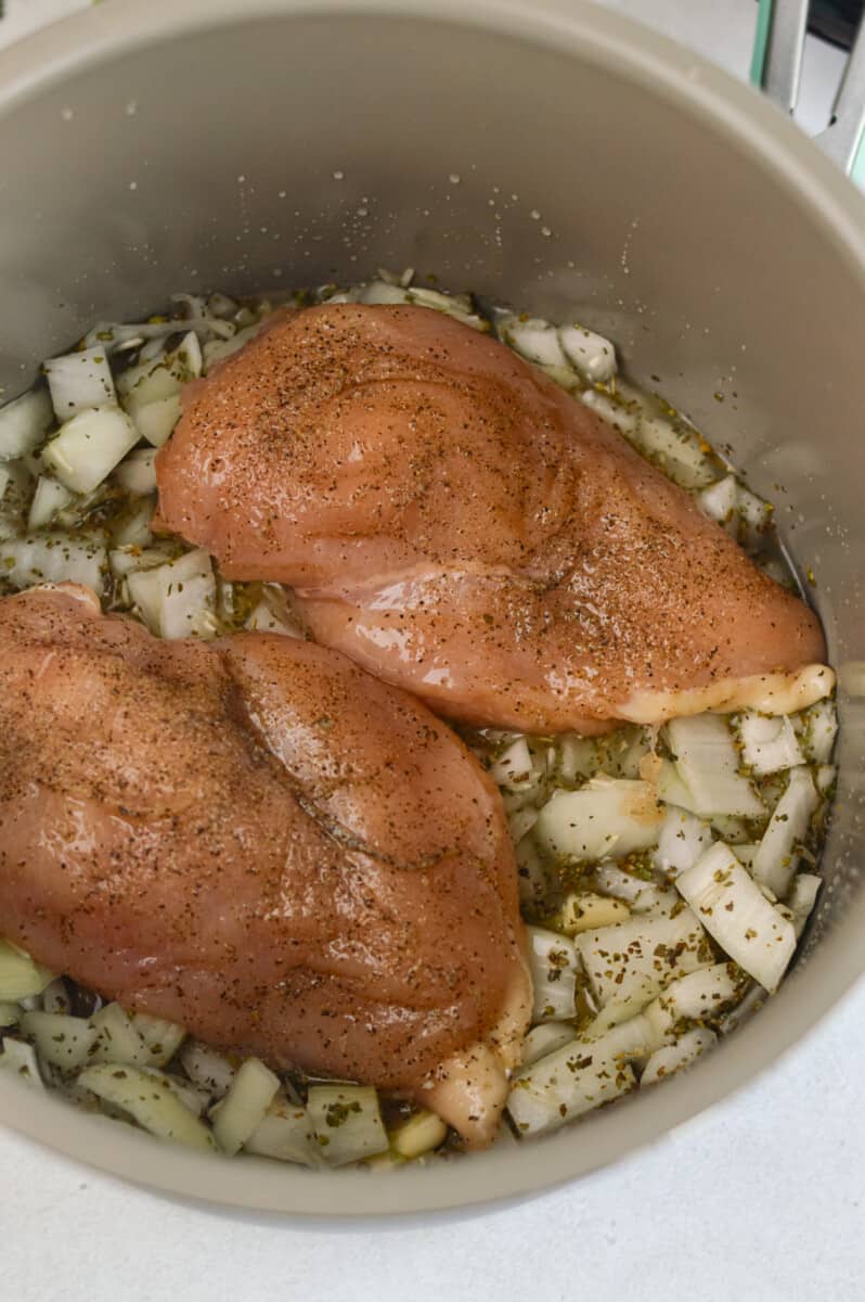 Adding chicken into crockpot.