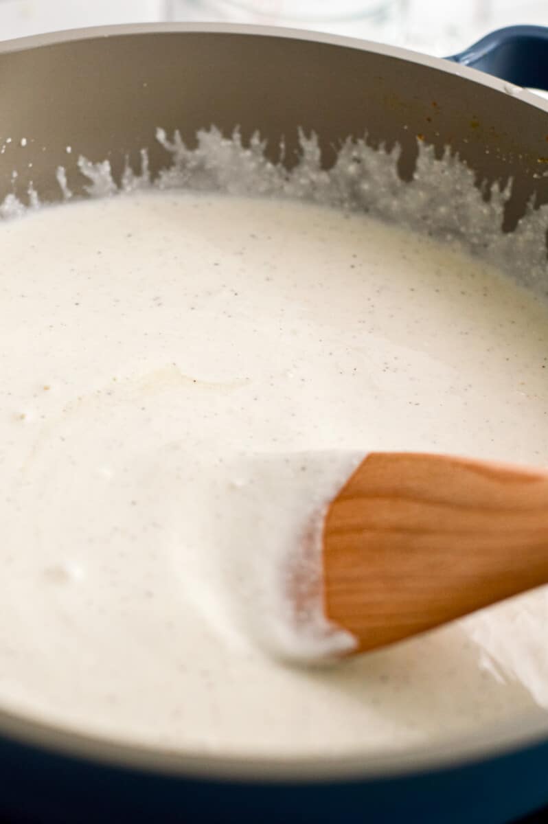Cooking cottage cheese alfredo sauce in a pan.
