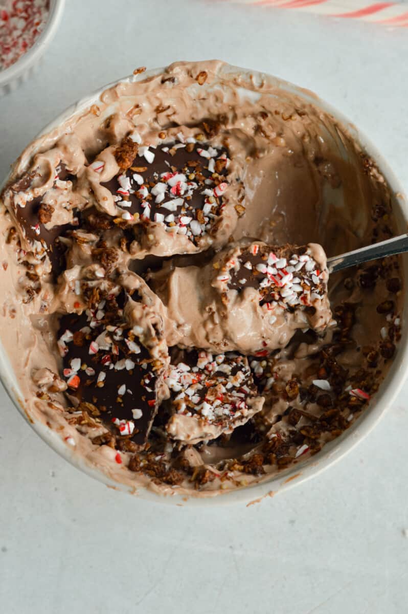 Cracking peppermint magic shell on chocolate Greek yogurt bowl.