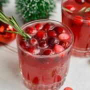 Cranberry ginger beer mocktail topped with raspberries and mint leaves.