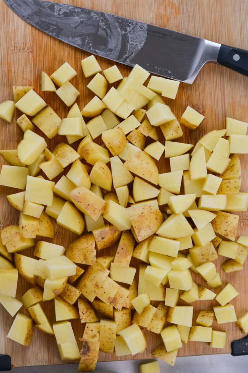 Dicing potatoes into cubes with a knife.