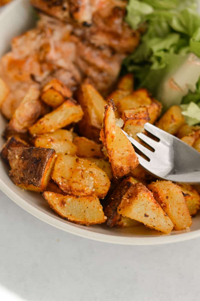 Eating air fryer diced potatoes with meat and veggies in a bowl.