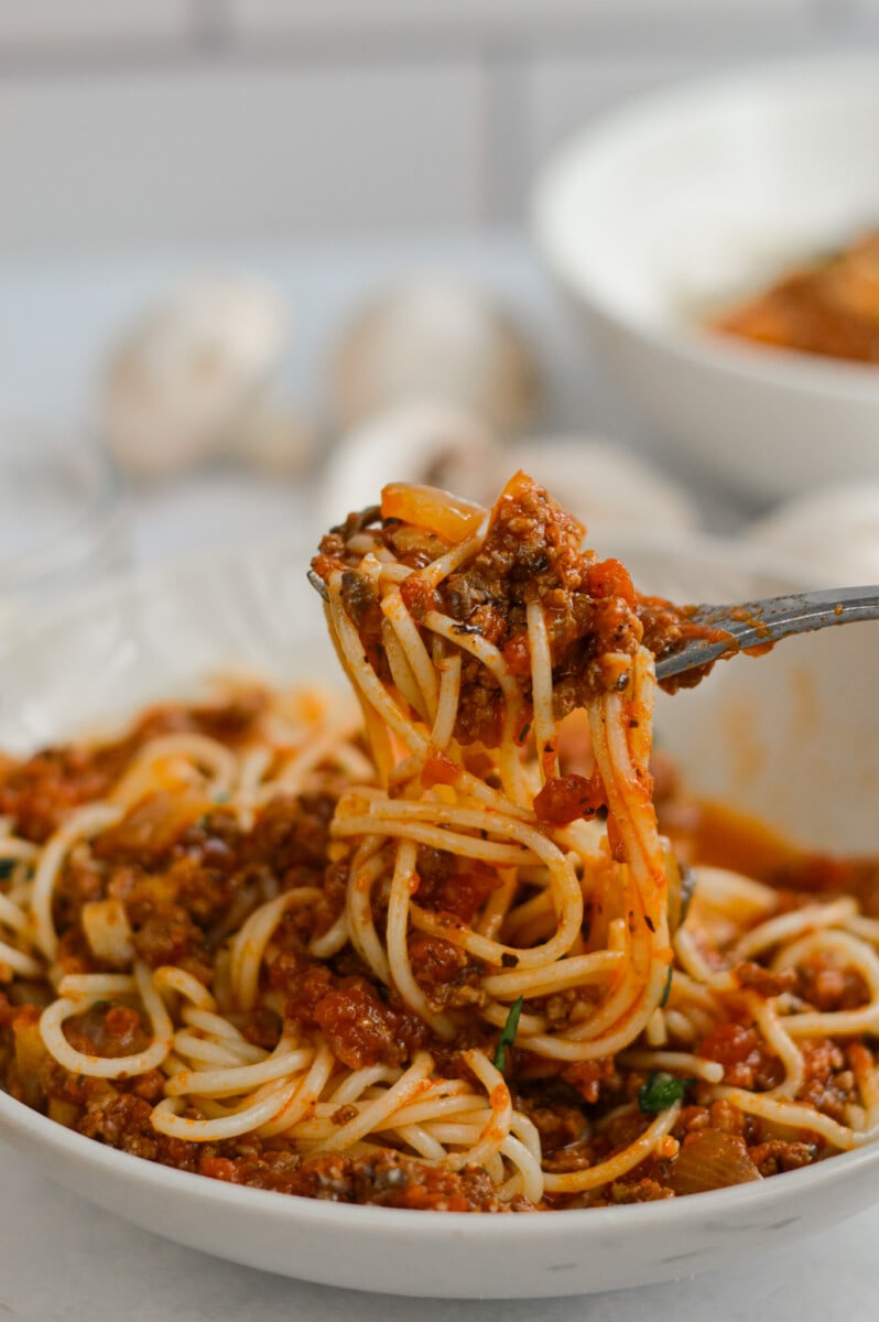 Fork twirling pasta with mushroom spaghetti sauce with ground beef.
