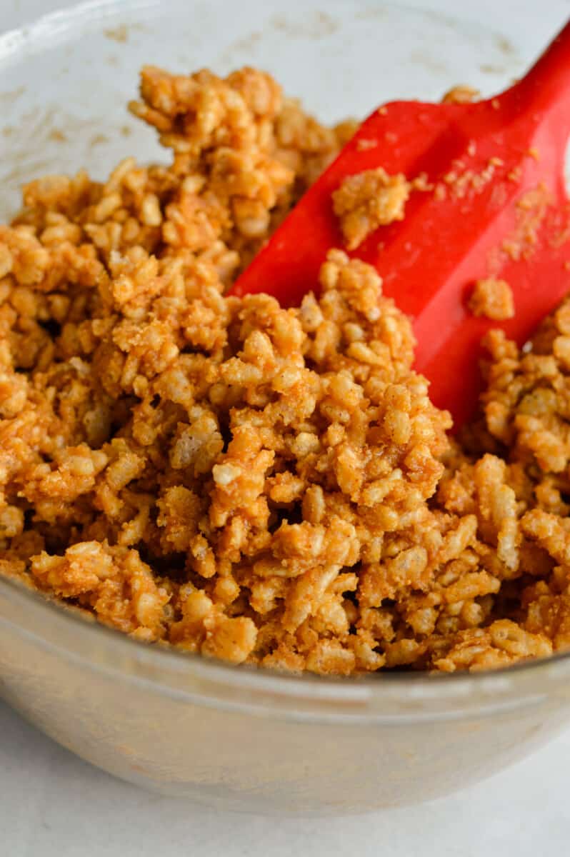 Mixing rice krispies into wet ingredients.