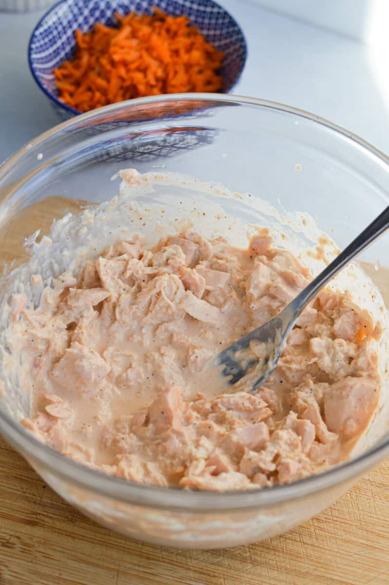 Using a fork to flake the tuna.