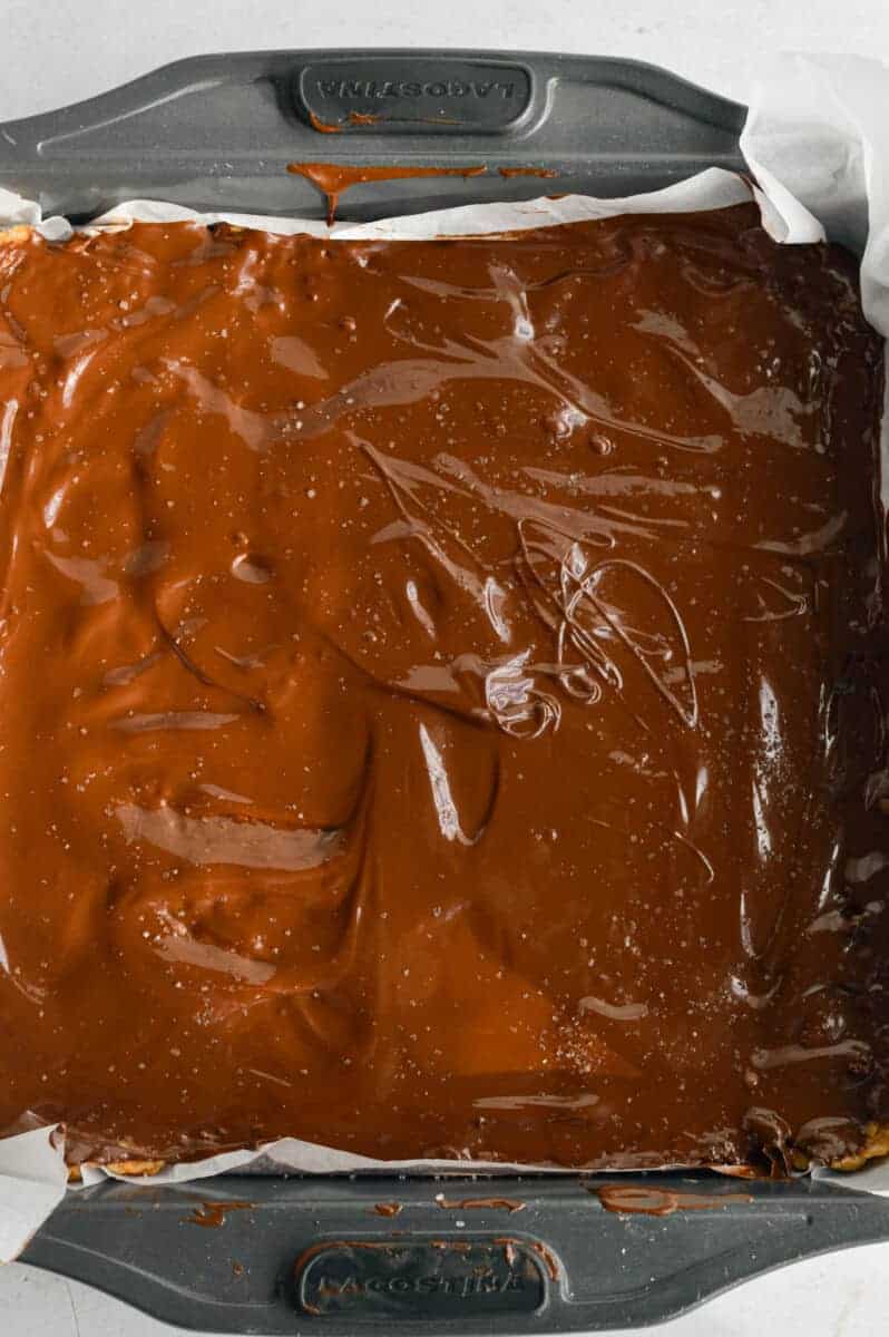 Pouring melted chocolate on homemade protein bars.