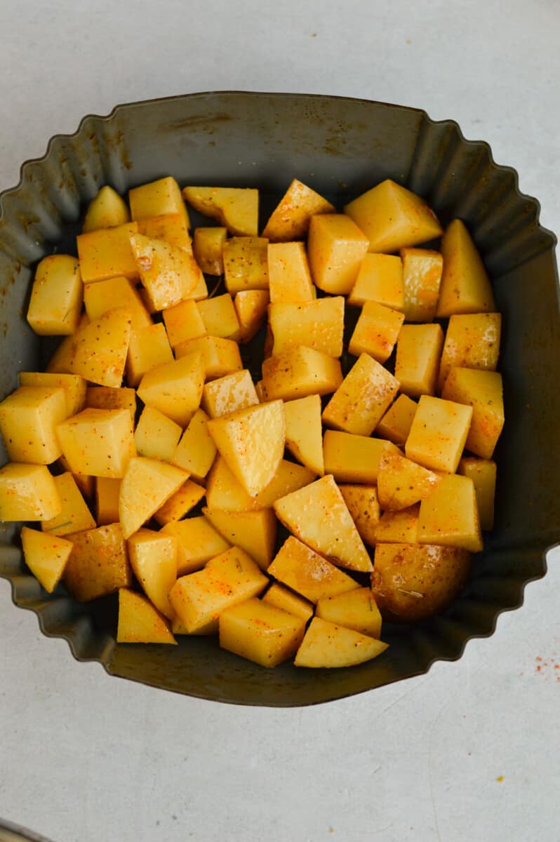 Diced potatoes in the air fryer, before cooking.