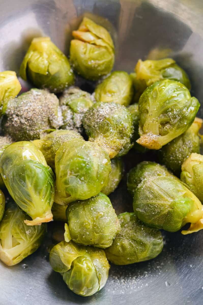 Seasoning Brussels sprouts with olive oil,  salt, pepper and maple syrup.

