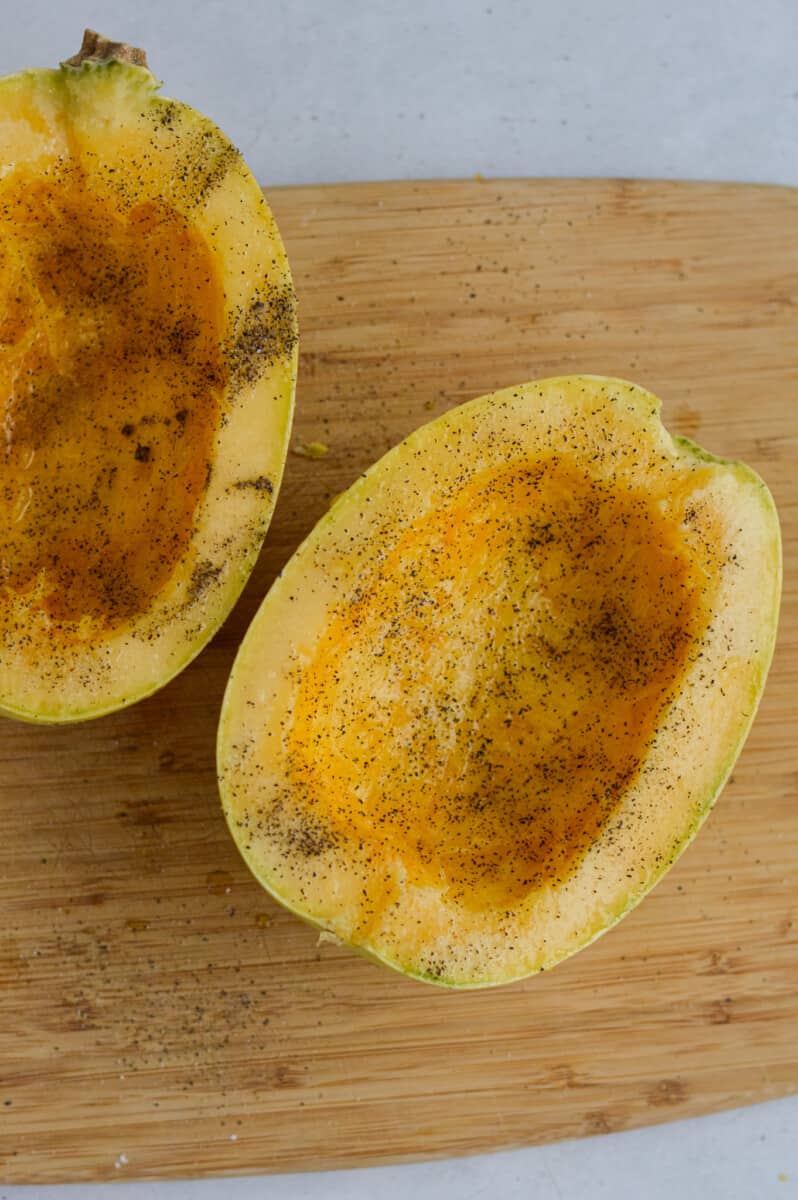 Seasoning spaghetti squash with olive oil, salt and pepper.