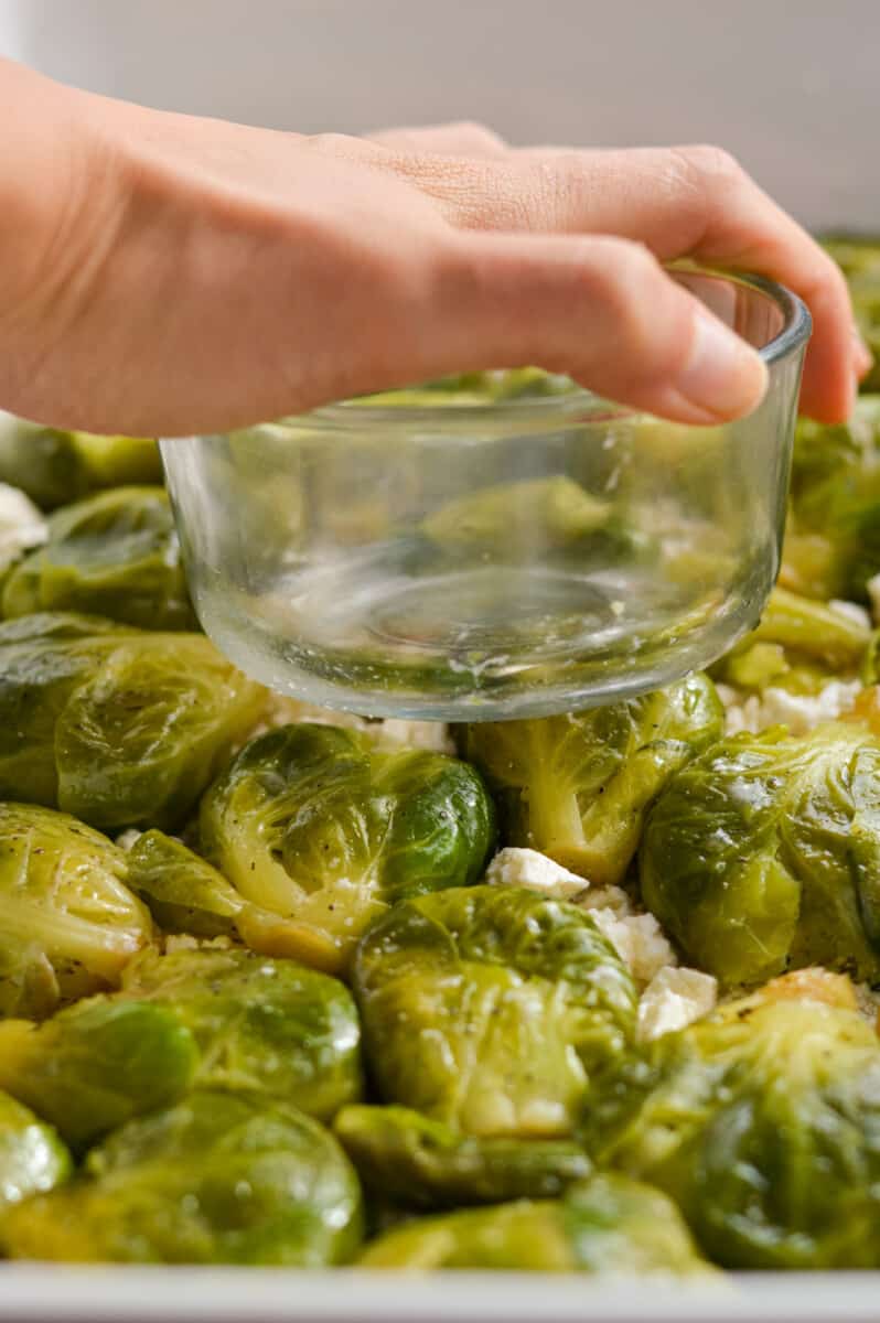Smashing Brussels sprouts with a glass bowl.