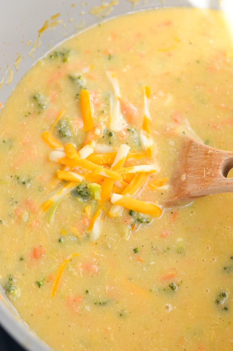 Stirring cheddar cheese into soup.