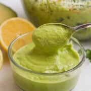 Using a spoon to scoop up avocado green goddess dressing.