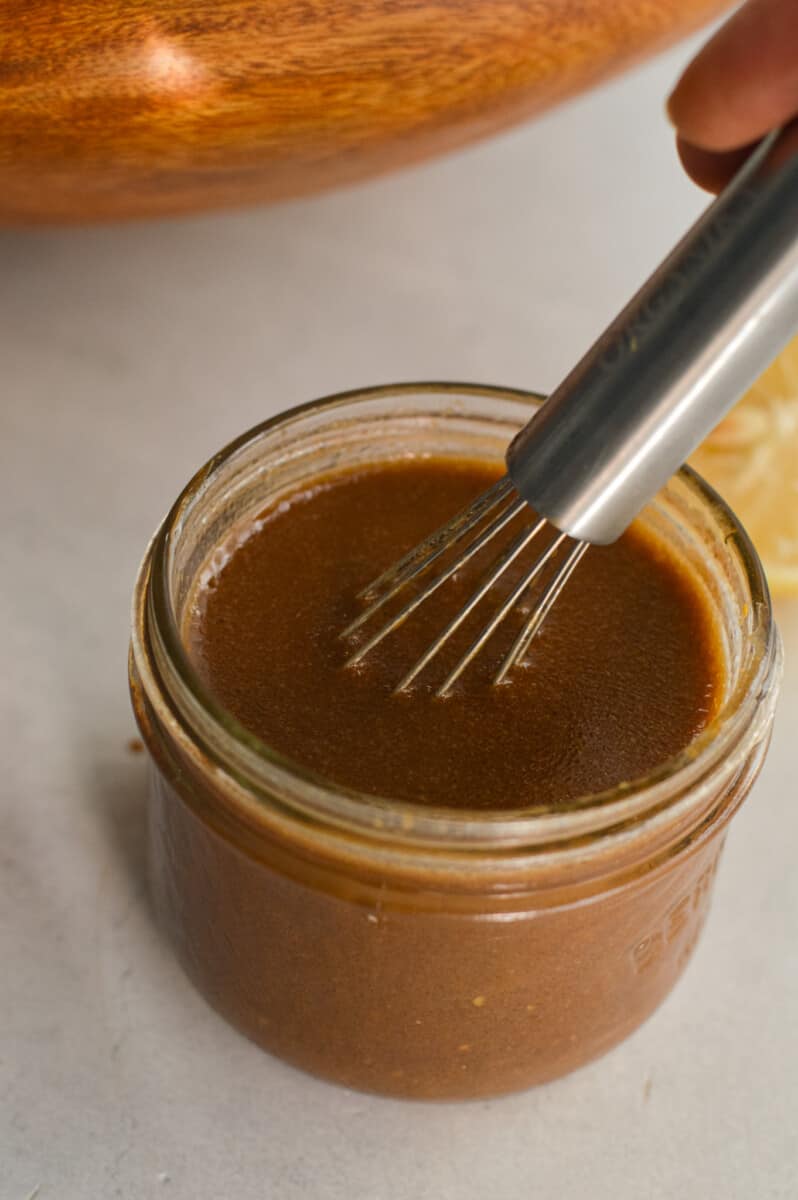 Mixing creamy balsamic dressing with a whisk.