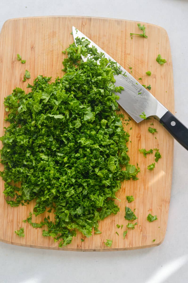 Dicing kale on a cutting board.