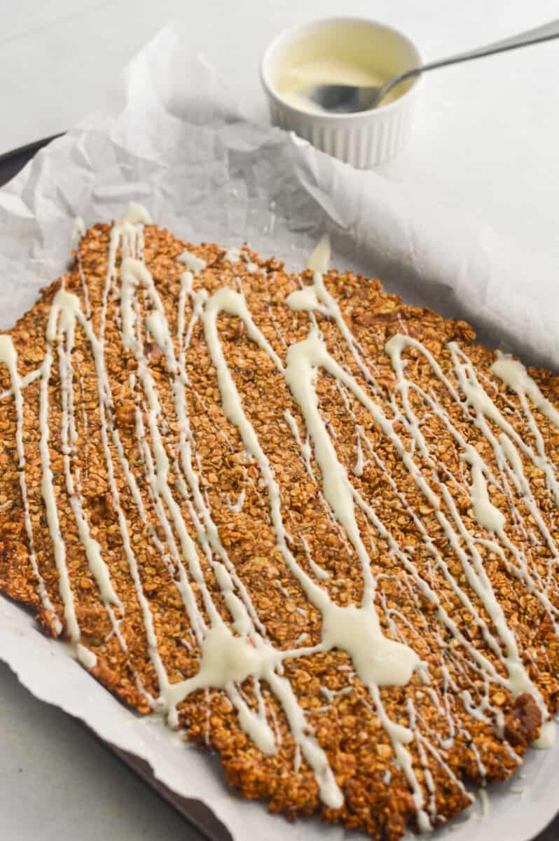 Drizzling white chocolate on cinnamon roll granola.