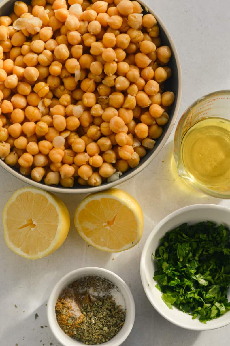 Ingredients including chickpeas, lemon, parsley, red onion, olive oil and spices