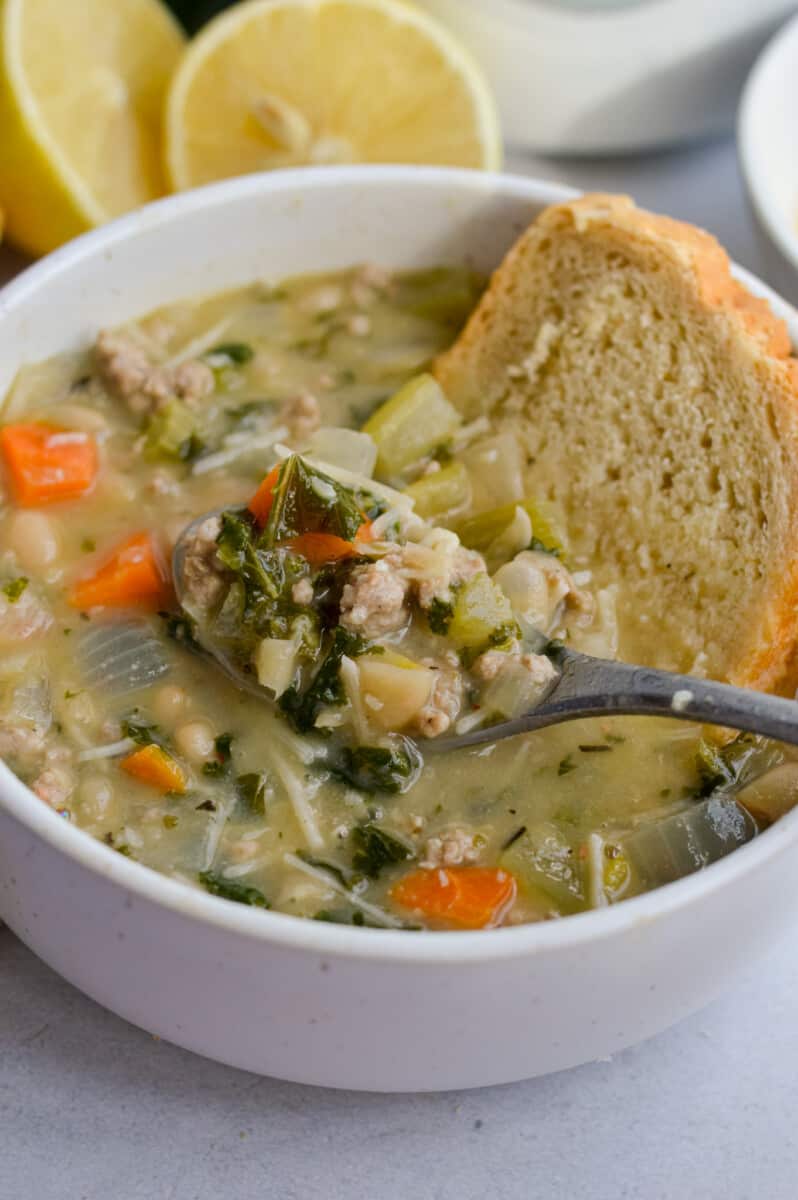 Lemon white bean soup with turkey and greens, served with bread.