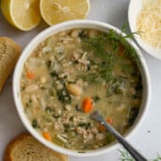 Bowl of lemon white bean soup with turkey and greens.