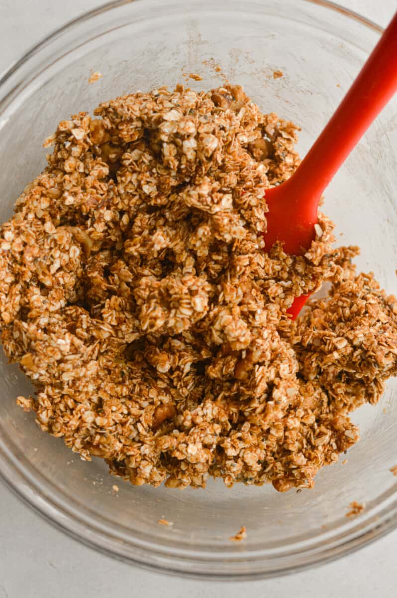 Mixing the oats, nuts, nut butter, honey, cinnamon, mashed banana, vanilla extract, and salt
