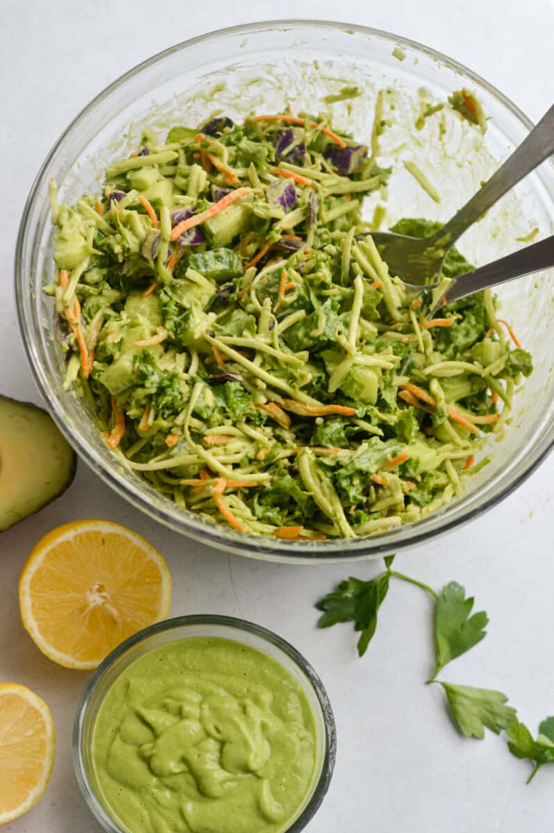 Mixing a salad with green goddess dressing.