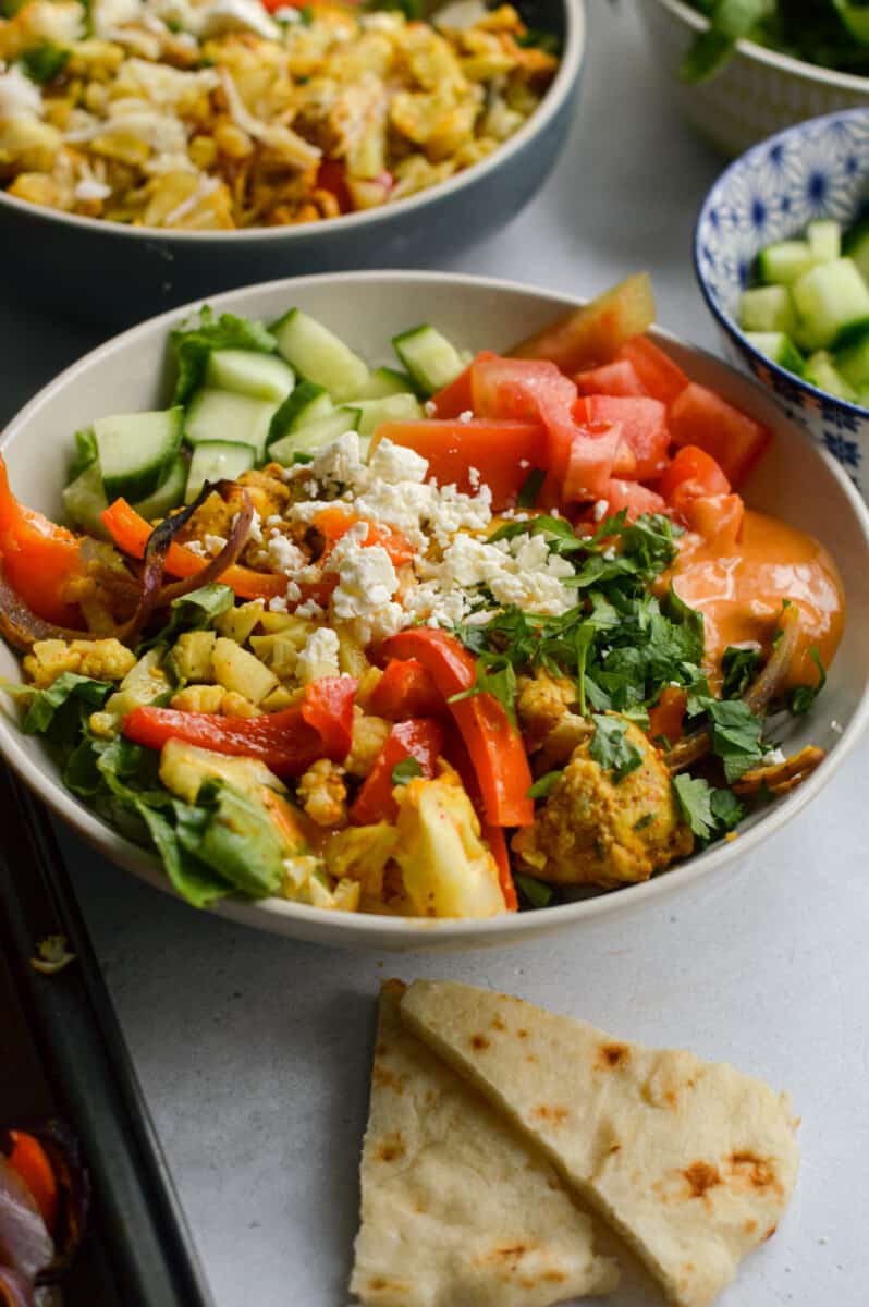 Chicken shawarma bowl with veggies, feta chees, cilantro and served with fresh pita.