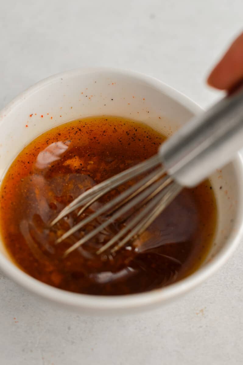 Whisking together oil, salt, black pepper, paprika and garlic. 
