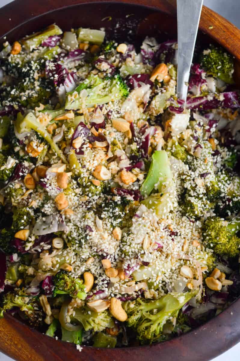 Tossing roasted broccoli salad with bang bang dressing.
