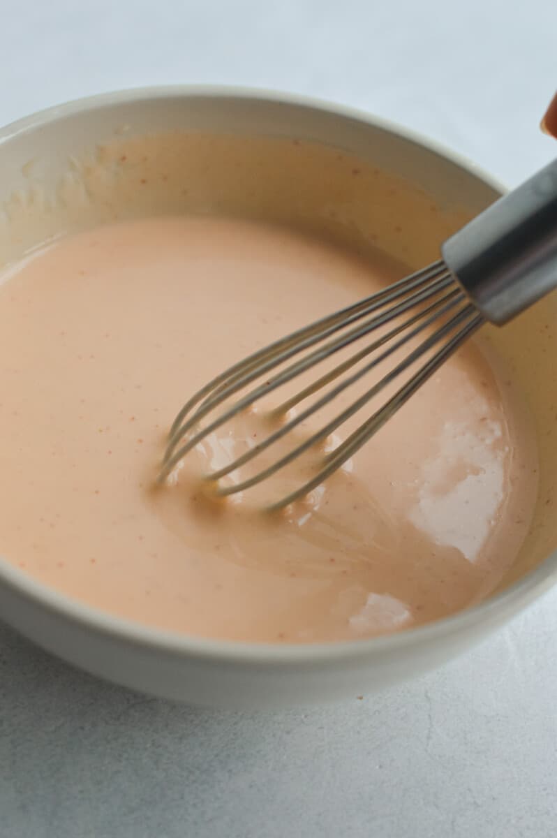 Mixing bang bang dressing with a whisk.