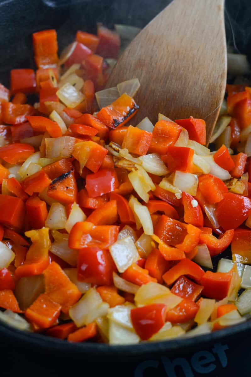 Sauteeing onions, garlic and red bell pepper in a skillet.
