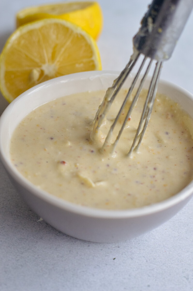 Whisking together Greek yogurt Caesar dressing.